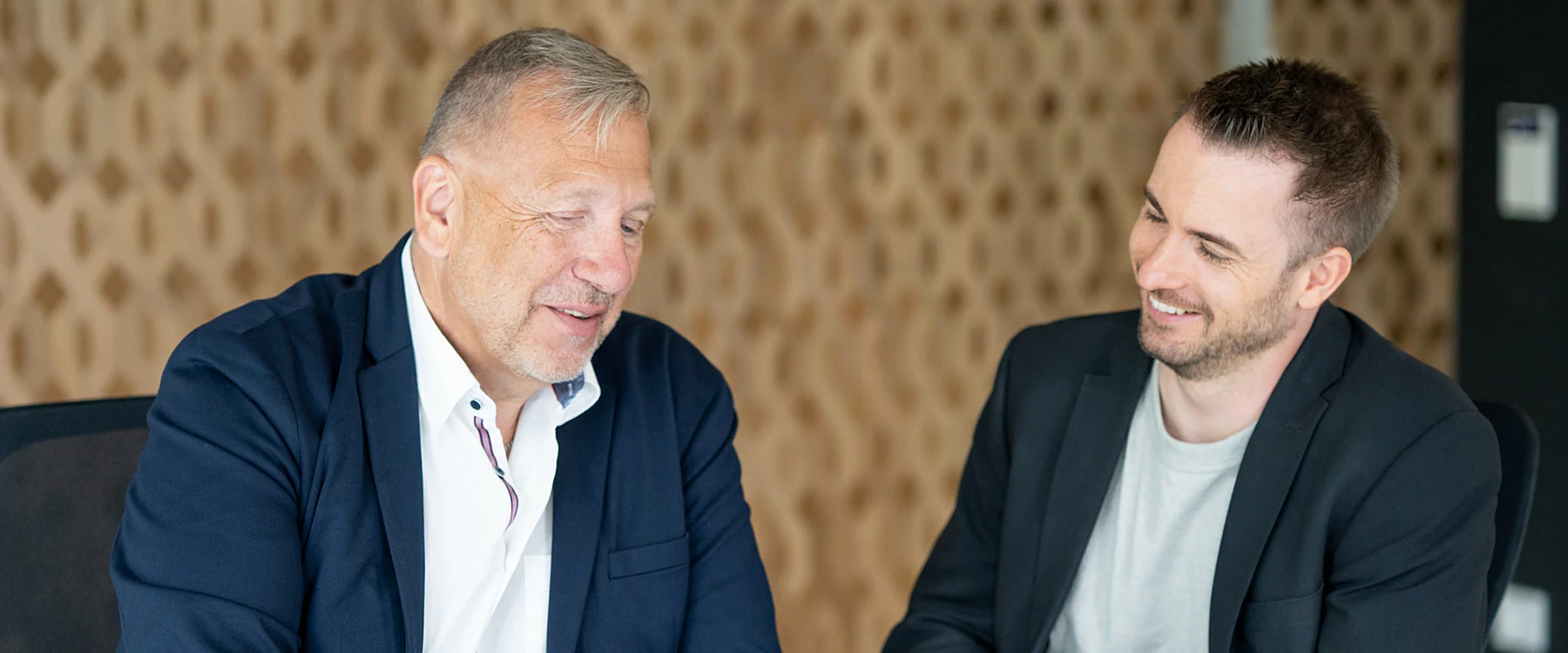 Zwei Personen besprechen gemeinsam Unterlagen an einem Tablet