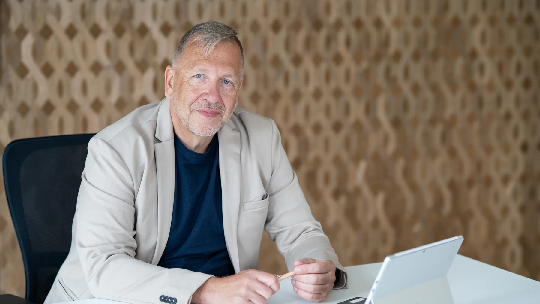 Marco Rausch sitzt mit einem Laptop am Besprechungstisch